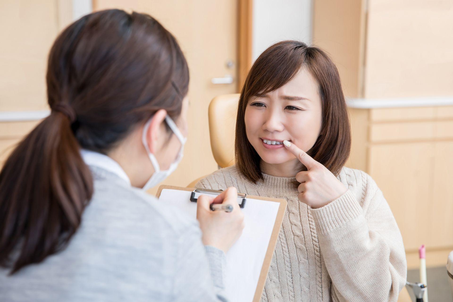 歯科医院で悩みを相談する女性